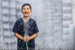 © Gatot - Happy asian boy playing with water using a hose