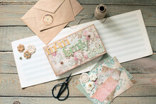 Scrapbooking. On A Wooden Background, A Girl Makes A Photo Album For A Family In A Vintage Style.