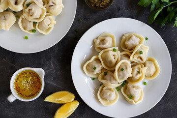 Wall Mural - Boiled meat dumplings in a white plate. The concept of a delicious lunch or dinner. Dumplings with green onions. Top view.