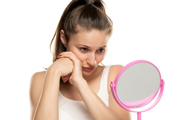 Wall Mural - young sad woman is bored and looking at herself in the mirror