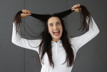 Crazy Woman Holds Hair And Makes Grimaces Closeup