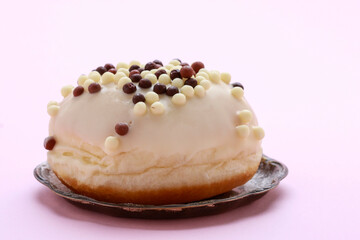 Canvas Print - A donut in white chocolate on a pink background.