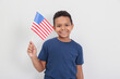 © New Africa - Happy African-American boy holding national flag on light background