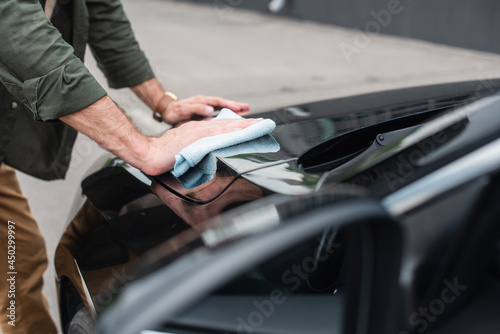 Cropped view of man waxing car outdoors