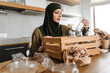© Drobot Dean - Smiling islamic woman in hijab sorting glass bottle