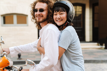 Happy young multiethnic couple on scooter