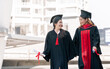 © Ann Rodchua - Two asian female beautiful students wearing uniform, cap and smiling with happiness after graduation. Education and Scholarship Concept.