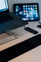 Wall Mural - Vertical shot of a laptop on a stand with a black keyboard on the table