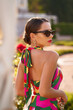 © Dmitry Tsvetkov - Close-up fashion portrait of elegant tanned caucasian woman in colorful stylish dress and sunglasses posing in palace garden on a sunny evening