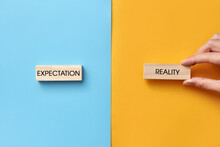 Wooden Plates With The Inscription: Expectation And Reality. A Symbol Of The Difference Between Expectation And Reality