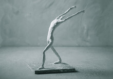 Plaster Sculpture Of Sportsman In Winner Pose On Concrete Background
