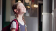 © TommyStockProject - Portrait of happy schoolgirl standing near window in school corridor enjoying sunshine