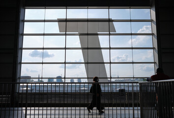 Poster - Woman walking by a window in Berlin Ostkreuz train station