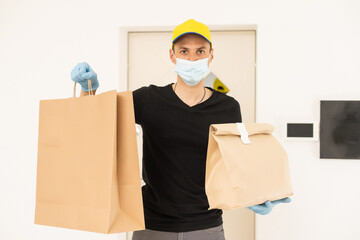 Wall Mural - Delivery man holding cardboard boxes in medical rubber gloves and mask. copy space. Fast and free Delivery. Online shopping and Express delivery. Quarantine