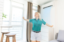 Women Enjoy The Coolness While Standing In Front Of The Air Conditioner