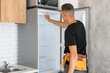 © Angelov - Young male worker repairing refrigerator