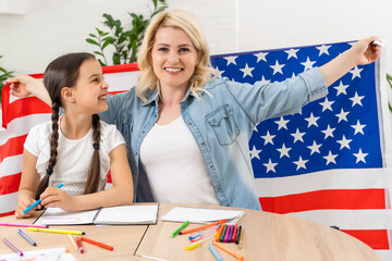 Wall Mural - happy mother and daughter with american flag at home