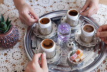 Women Holding Turkish And Greek Coffee Cups Inside Metal Tray, Lace Cover On Wooden Table