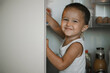 © Anastasia Amraeva - A child opens the refrigerator door at home in the kitchen. A 2-year-old boy in front of the refrigerator.