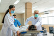 © godji10 - Doctor and male nurse moving injured patient on a gurney