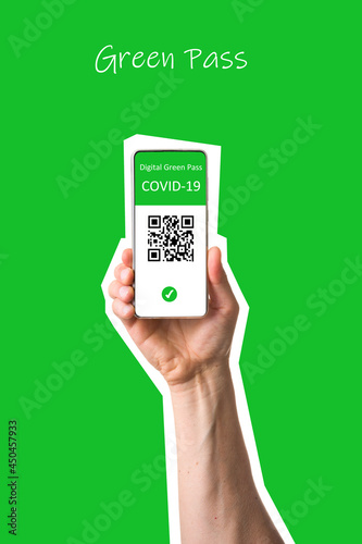 The digital green pass of the EU with the QR code on the screen of a mobile held by a hand with  green background. Immunity from Covid-19. Permit to travel without restrictions in Europe.