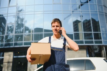 Smiling delivery man standing in front of his car