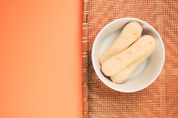 Sticker - Top view of ladyfinger cookies on bamboo wicker tray isolated on an orange background