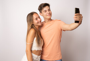 Portrait of happy couple making selfie, isolated on white background.