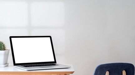 Wall Mural - Mockup blank white screen laptop computer on the table in living room.