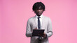 © LIGHTFIELD STUDIOS - african american man in suit writing on clipboard isolated on pink
