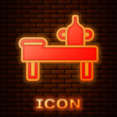 Sticker - Glowing neon Massage table with oil icon isolated on brick wall background. Vector