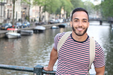 Young mixed race man enjoying a European cityscape view with a river