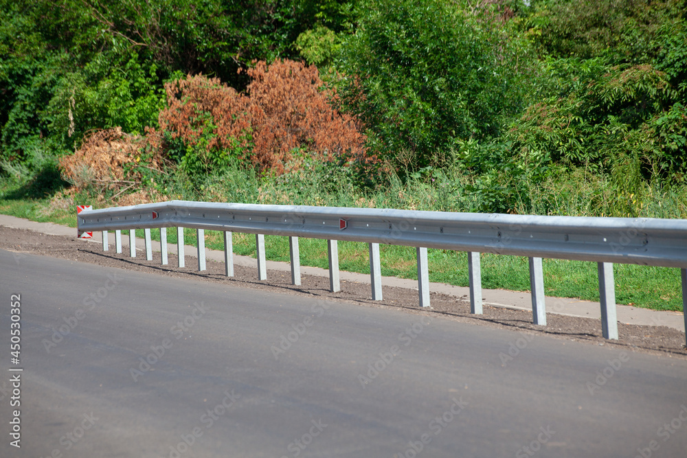 red road reflectors along the road. metal road fencing of barrier type ...
