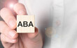 Man holding aba word on wooden cube.