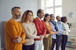 © Studio Romantic - Happy diverse multiethnic team with people of different ages holding hands together united by goal standing in row. Corporate business training in modern office. Unity trust support teamwork