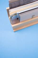 Wall Mural - Vertical shot of filled documents on a wooden shelf isolated on blue background