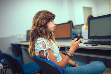 Sticker - College students using phone in a computer lab