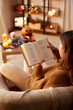 © Syda Productions - halloween, holidays and leisure concept - young woman reading book at cozy home