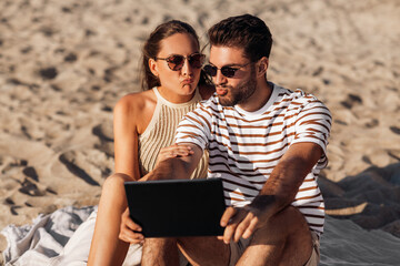 Poster - leisure and people concept - happy couple with tablet pc computer on summer beach