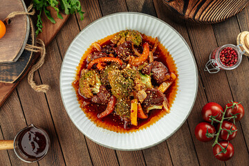 Wall Mural - Aisan stewed beef with broccoli and pepper dish on a wooden background