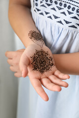 Wall Mural - Little girl with henna tattoo on palm, closeup. Traditional mehndi ornament