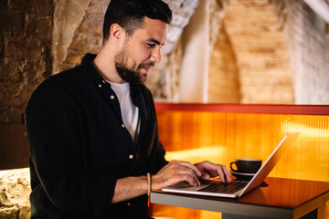 Happy businessman using laptop computer at cafe