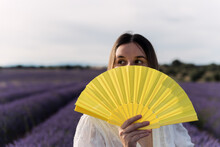 Woman With A White Dress With A Yellow Fan In Lavender Fields.