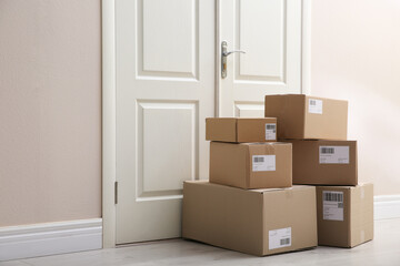 Wall Mural - Stacked parcels near door on floor. Delivery service