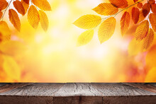 Empty Wooden Table And Orange Autumn Leaves Over Blurred Nature Background. Fall Background With Empty Space For Product Display