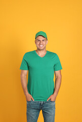 Wall Mural - Happy man in green cap and tshirt on yellow background. Mockup for design