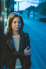 Wall Mural - Vertical shot of a young European lady wearing a blouse and a leather jacket in the evening