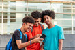 © Viviland - Multiethnic friends using mobile phone in the street