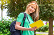 © luismolinero - Young student woman at outdoors holding a notebook