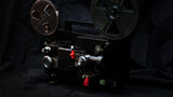 Fototapeta Panele - Old vintage movie projector on a dark background with fog and light. Concept of film-making.